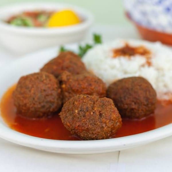 Habayit Restaurant's meatballs in red sauce with white rice and a side salad.