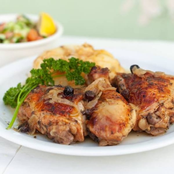 Habayit Restaurant's Israeli chicken with onions, raisins, and parsley, served with mashed potatoes and salad.